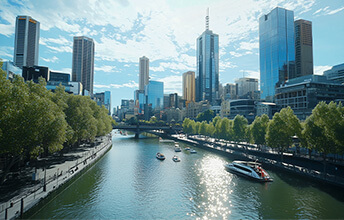 View of Melbourne City Business District skyline with modern skyscrapers, Yarra River, and boats on a sunny day in Australia.